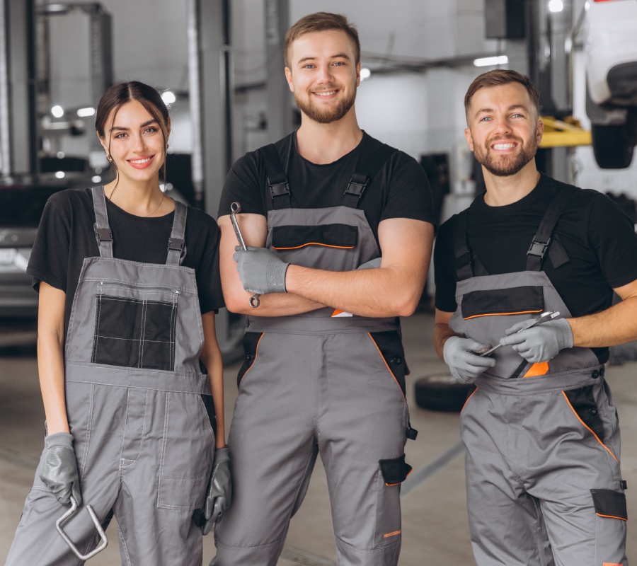 Techniciens qualifiés et passionnés – L’équipe Truth Pare-Brise Équipe de techniciens automobile souriants dans un atelier de réparation, service professionnel Truth Pare-Brise